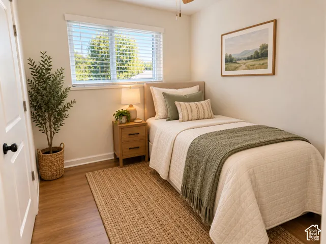 Room featuring wood-finish flooring, a neutral color palette, and a window with horizontal blinds