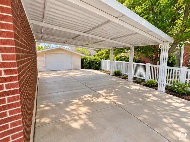 Covered carport with white metal roofing and support columns