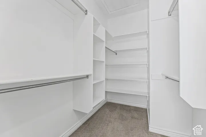 Custom closet system with multiple shelving units and hanging rods