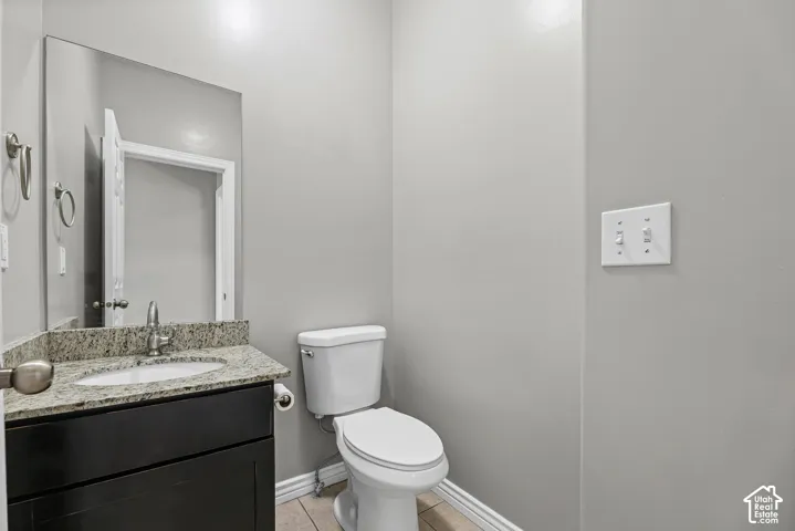 Vanity with a polished granite countertop, undermount sink, and dark wood-finish cabinetry