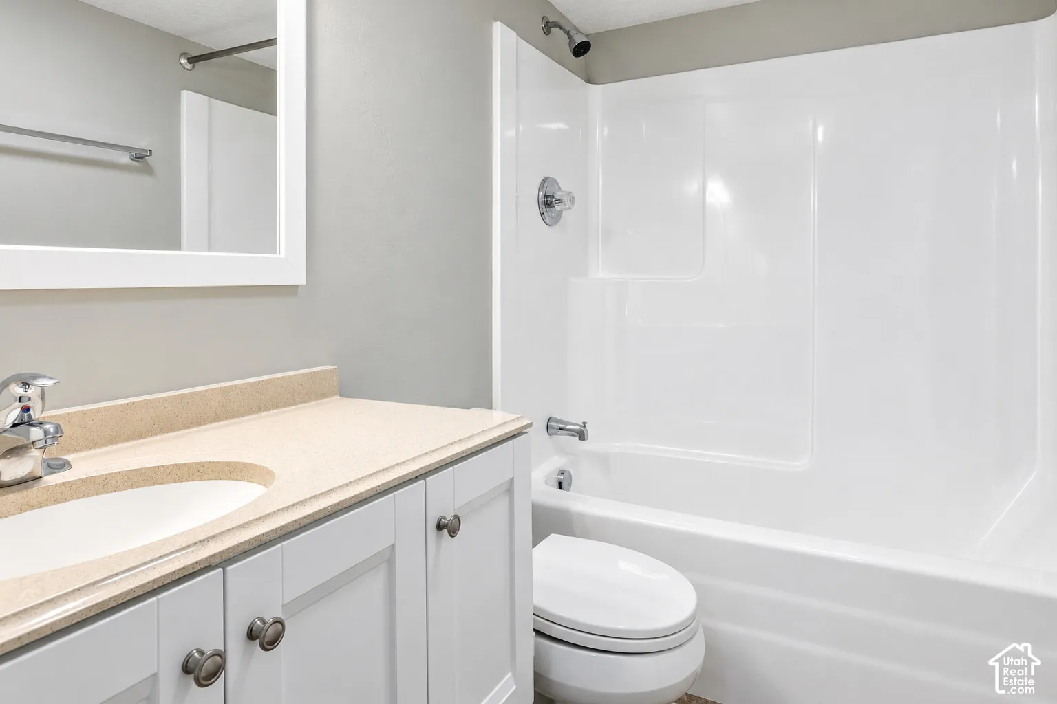 White vanity with brushed nickel hardware, integrated sink, and light-colored countertop