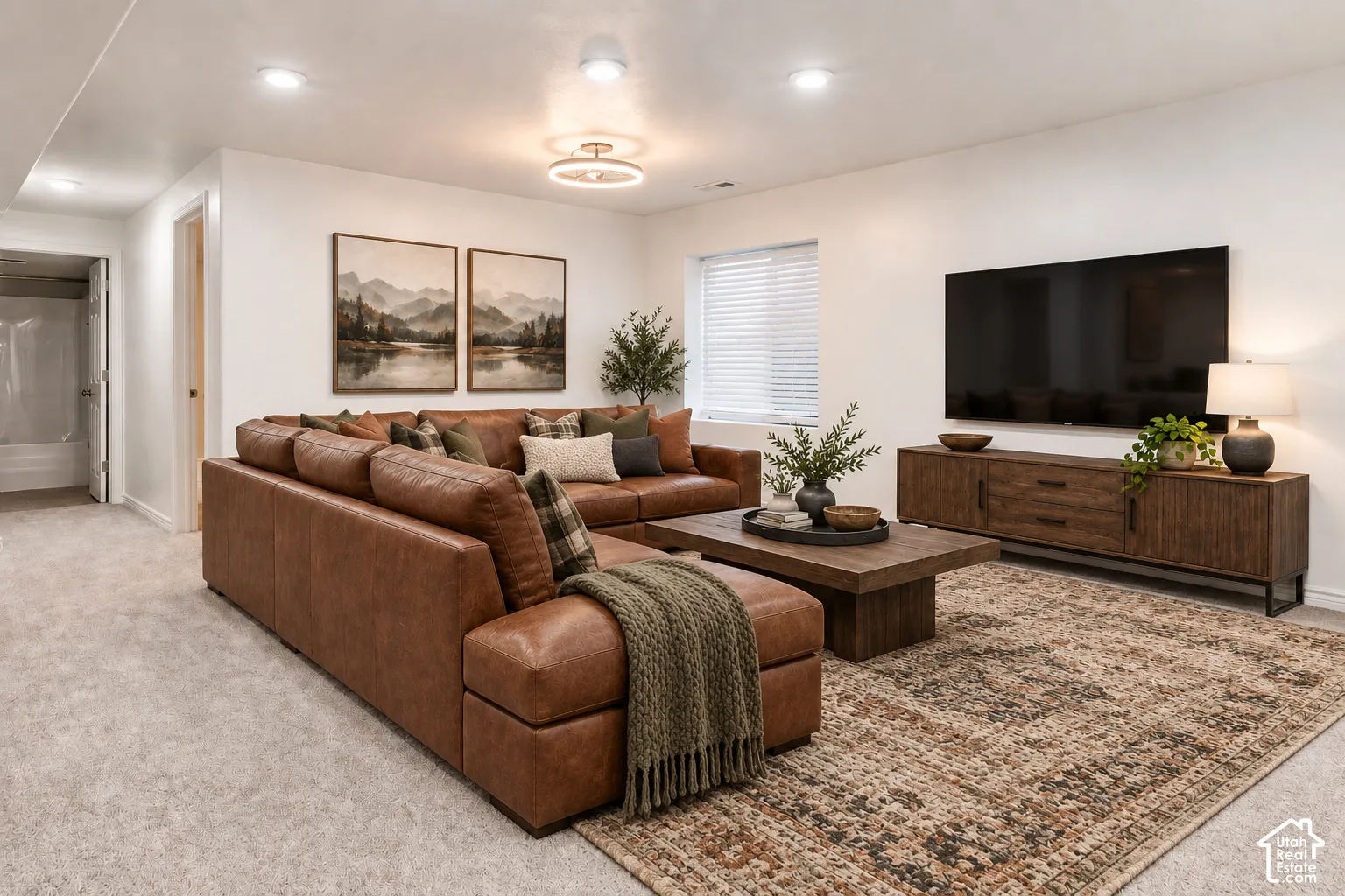 Recessed lighting and a modern semi-flush mount fixture illuminate this space, featuring light-colored carpeting and a window with blinds
