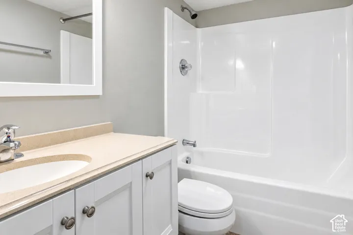 White vanity with brushed nickel hardware, integrated sink, and light-colored countertop