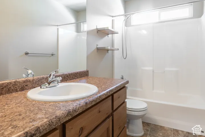 Full vanity mirror over a wood-finish cabinet with an integrated sink and a stone-look countertop