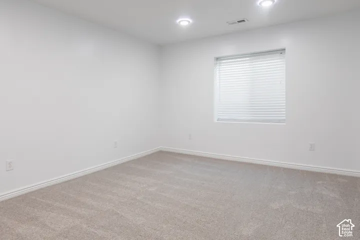 Recessed lighting, carpeted flooring, window with blinds, and white walls