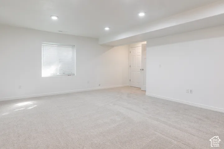 Plush carpet flooring, recessed lighting, white walls, and a window with blinds