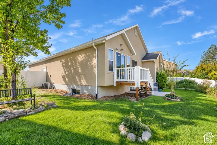 Exterior featuring a stucco finish, ground-level windows, a white deck with railings, and a concrete patio