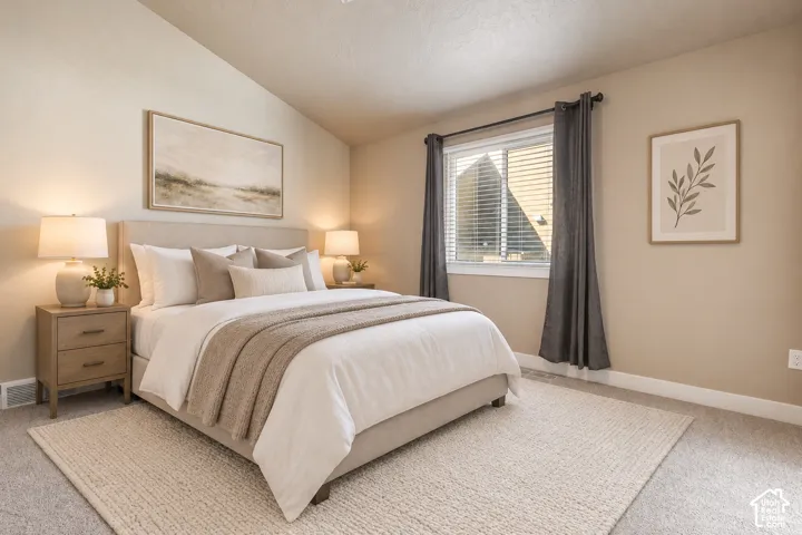 Vaulted ceiling, carpet flooring, window with blinds, wood-finish nightstands, upholstered bed frame