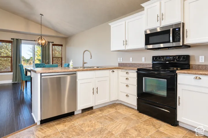 Kitchen featuring white cabinetry, light-toned countertops, a stainless steel dishwasher, an oven, and an overhead microwave