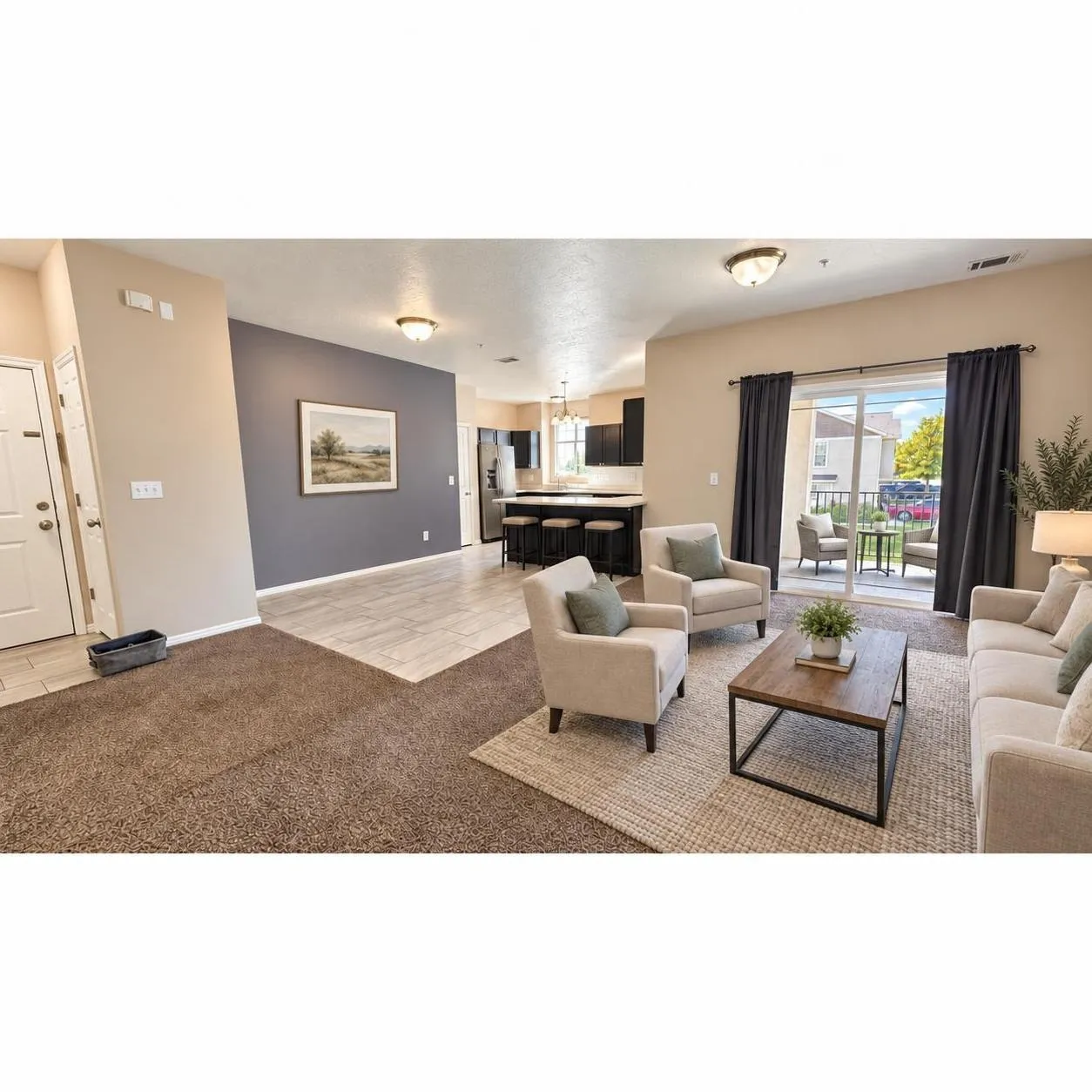 Open-concept main room featuring neutral carpeting, tile flooring, a dark-toned accent wall, and a sliding glass door