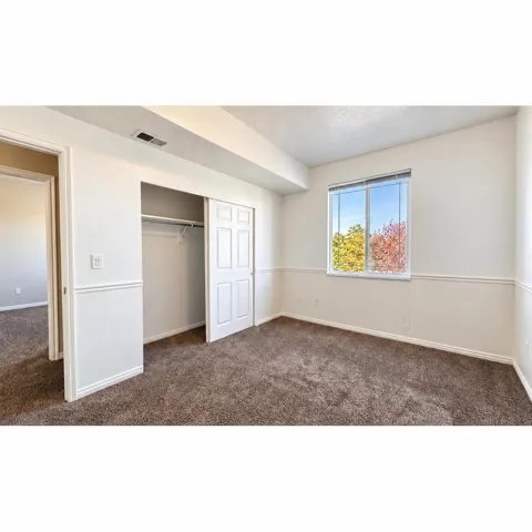 Bedroom 2Brown carpet flooring, white walls, picture rail molding, white interior doors, and a double-pane window