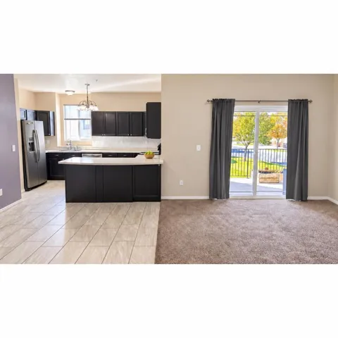Kitchen featuring dark cabinetry, stainless steel appliances, and an island with counter seating
