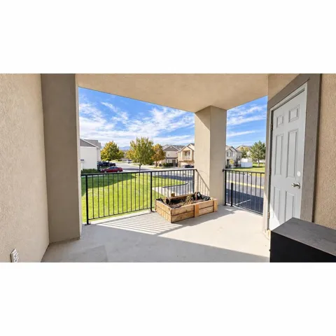 Covered balcony featuring concrete flooring and black metal railings