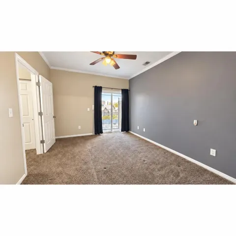 Primary Bedroom  Spacious room featuring carpeting, a ceiling fan with integrated lighting, and a sliding glass door for outdoor access