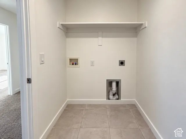 Built-in overhead shelving, tile flooring, and utility hookups