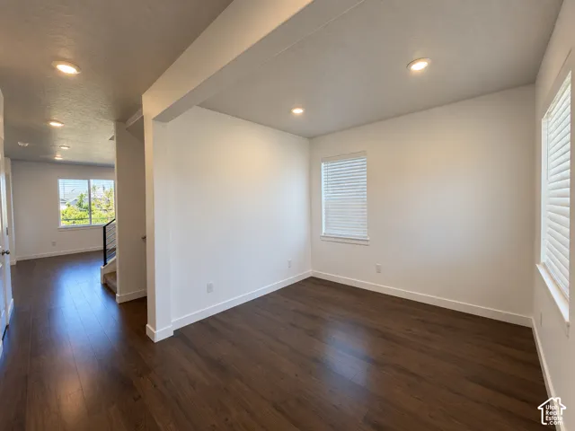 Recessed ceiling lighting, wood-finish flooring, white painted walls, multiple windows with blinds, and white trim throughout