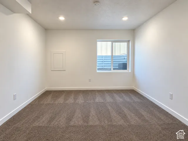 Recessed ceiling lighting, white walls, carpet flooring, a window, and white trim