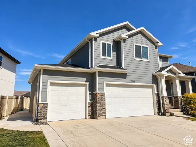 Two-story residence featuring gray horizontal siding and stone accents