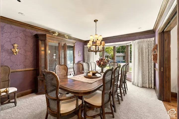Tray ceiling with a decorative chandelier, bay window, and patterned wall covering