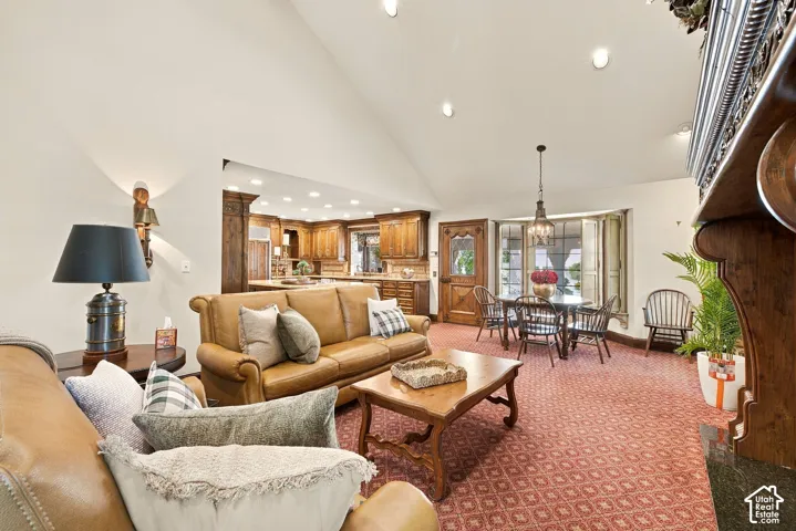 Vaulted ceiling, recessed lighting, and a kitchen with wood cabinetry