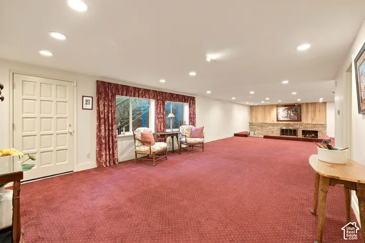 Spacious room with recessed lighting, red carpeting, and a brick fireplace
