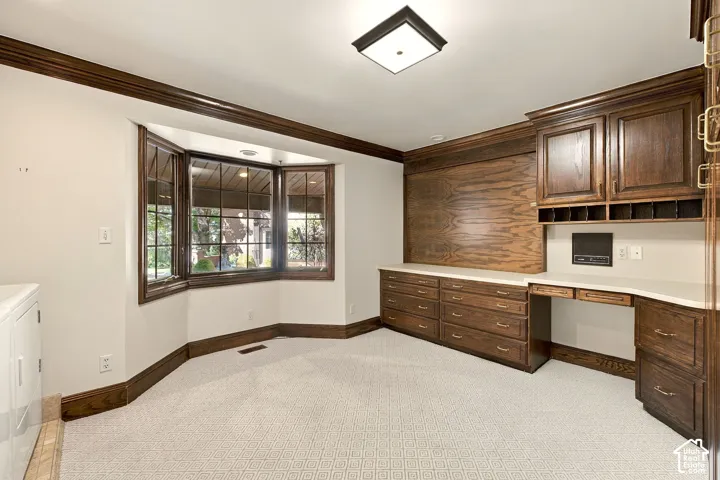 Extensive built-in cabinetry with a desk area, light-toned countertops, and dark wood-finish trim