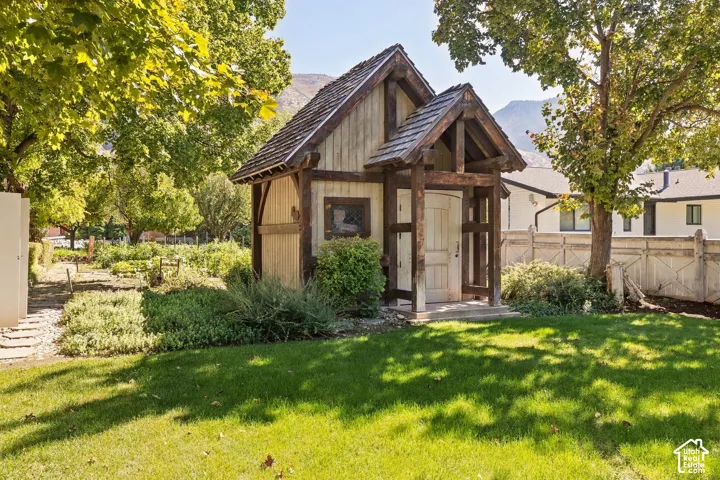 Detached outbuilding with a prominent front entrance, wood siding, and a shingled roof