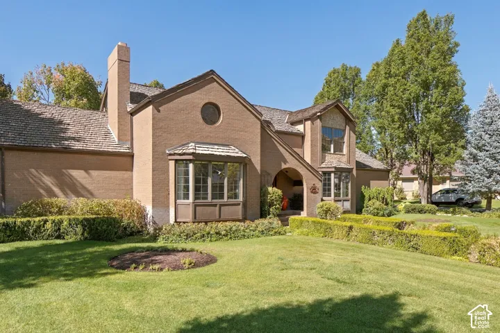 Brick exterior with a prominent chimney, bay window, and gabled rooflines