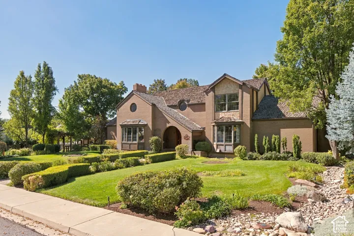 Brick exterior with a shingle roof and multiple bay windows