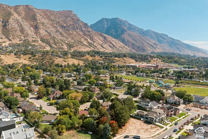 Expansive residential area featuring numerous single-family homes, mature trees, and mountainous terrain