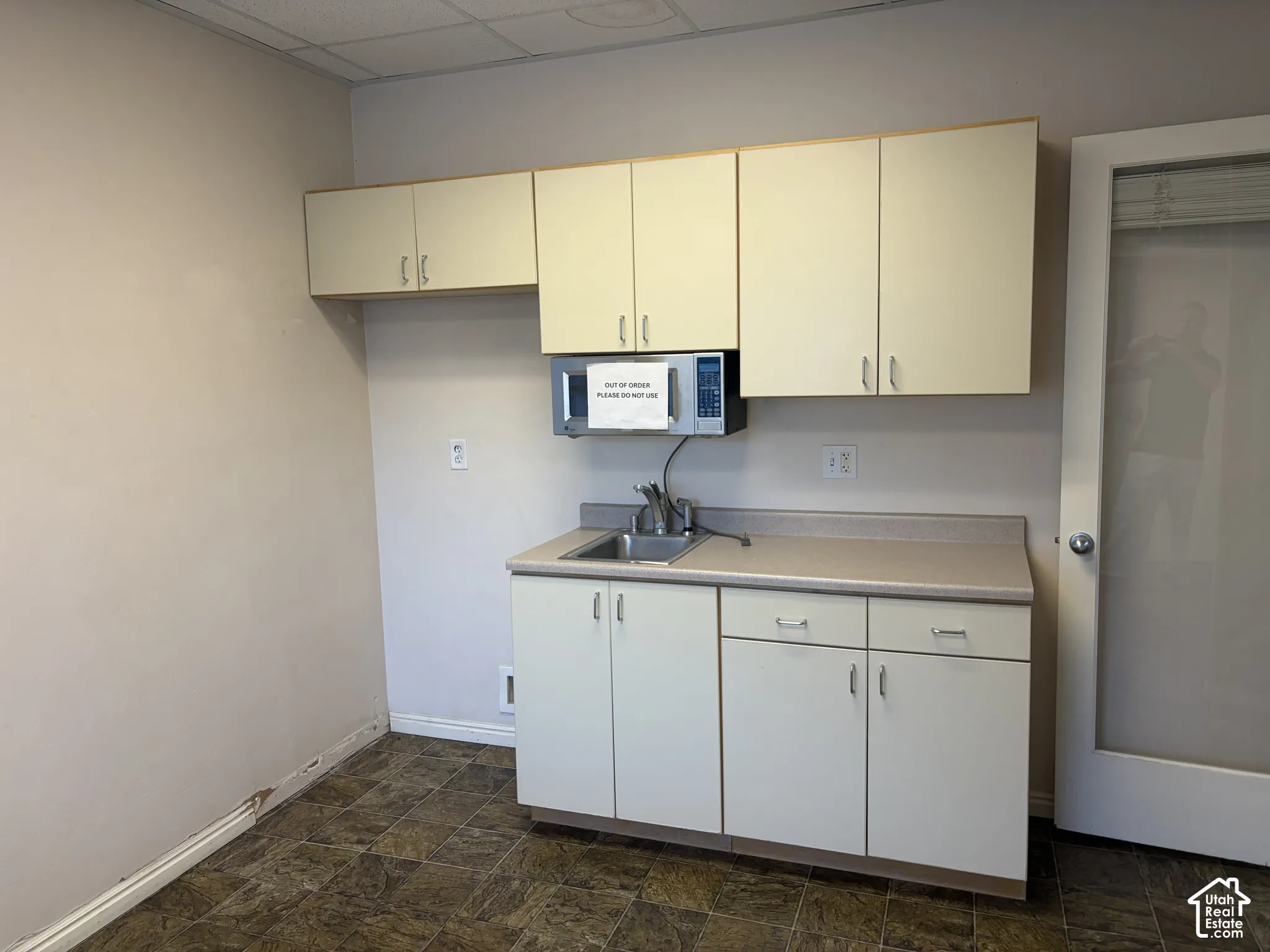 Built-in cabinetry with a laminate countertop, stainless steel sink, and wood-finish flooring