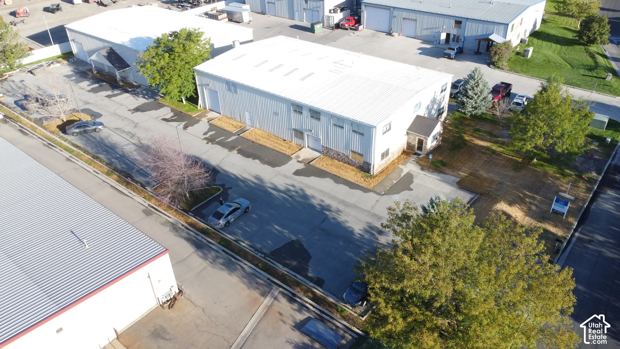 Industrial building with a metal roof, multiple bay doors, and paved parking