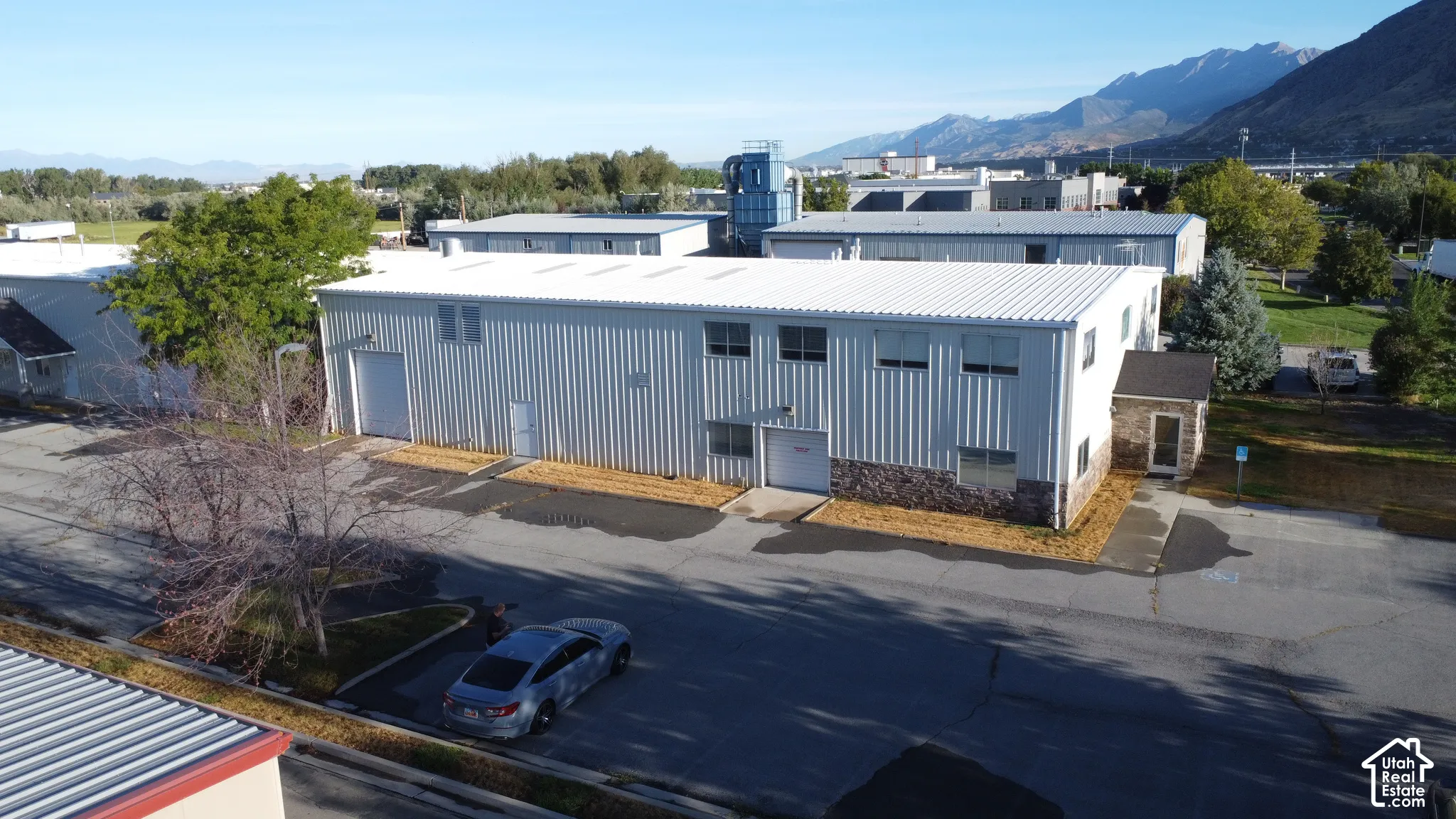 Industrial building with metal siding, multiple windows, and a stone veneer accent