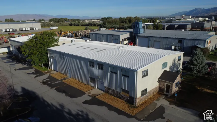 Commercial structure featuring a corrugated metal roof, multiple windows, and a stone-clad entrance