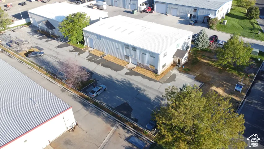 Industrial building with a metal roof, multiple bay doors, and paved parking