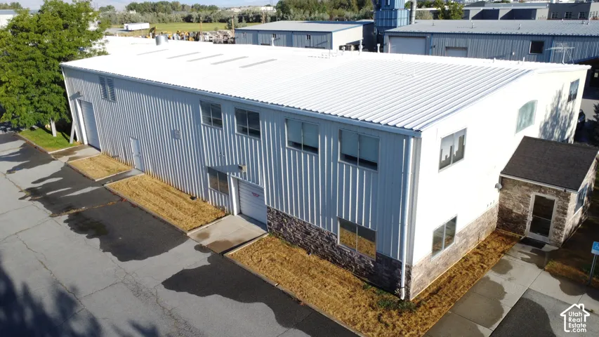 Metal-clad commercial building with a corrugated roof, stone veneer accents, and multiple windows