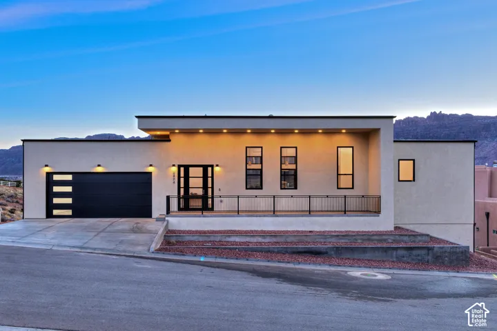Contemporary stucco exterior with a flat roofline, integrated garage, and a covered entry porch