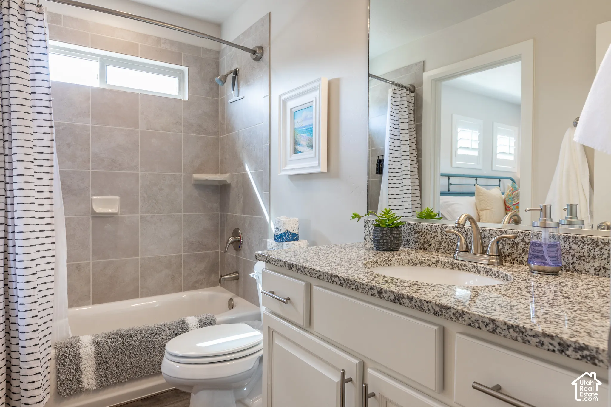 White vanity with brushed nickel hardware, light-toned granite countertop, and undermount sink