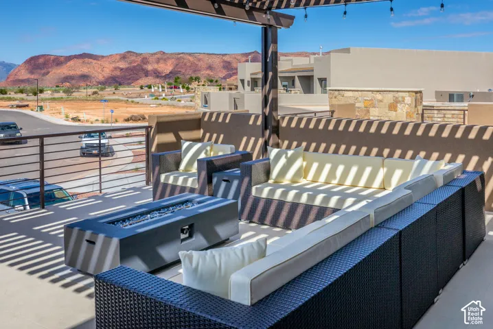 Rooftop deck featuring a slatted pergola, metal railing, and an integrated fire pit