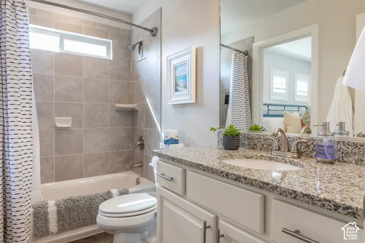 White vanity with brushed nickel hardware, light-toned granite countertop, and undermount sink