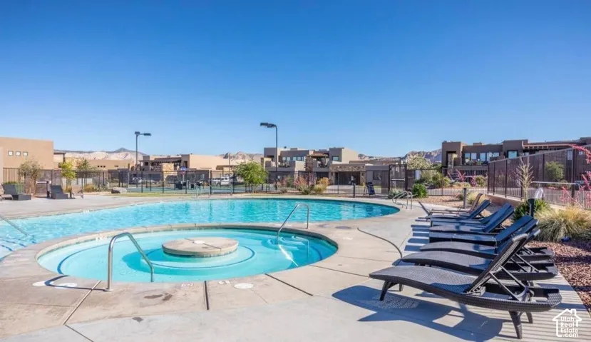 Outdoor pool with integrated spa and surrounding concrete patio