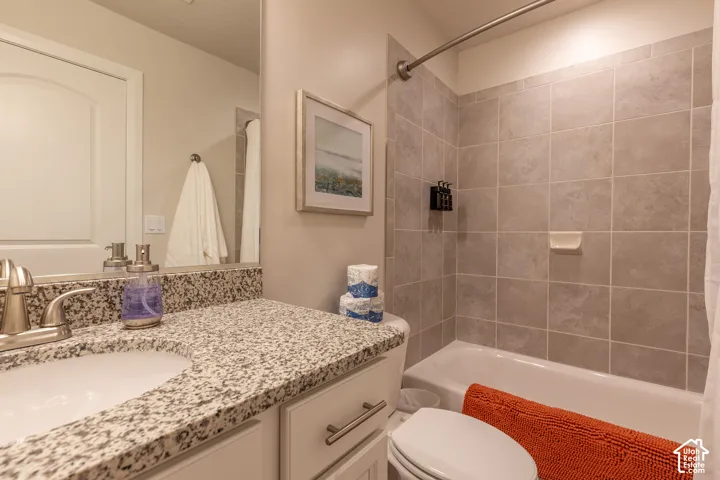 Spa-inspired bathroom featuring a granite-topped double vanity with brushed nickel fixtures, frameless glass shower enclosure with tile surround, and a soaking tub