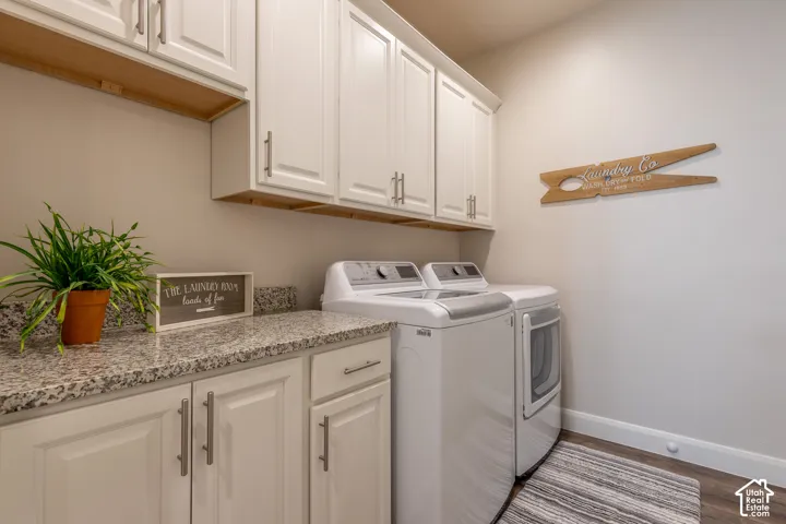 White cabinetry with brushed nickel hardware, speckled countertop, and wood-finish flooring