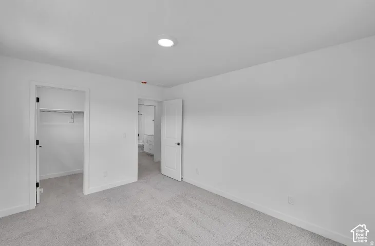 Recessed lighting illuminating a spacious room with light gray carpeting