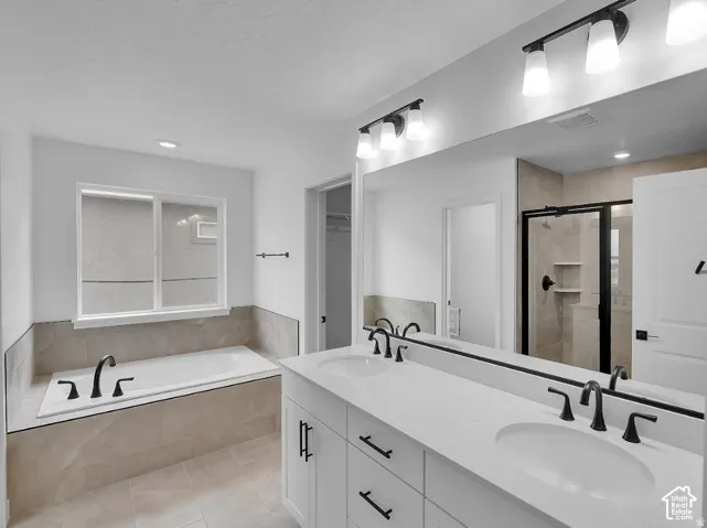 Dual vanity with undermount sinks and black fixtures, expansive mirror, built-in soaking tub, and a separate shower with a black-framed glass enclosure