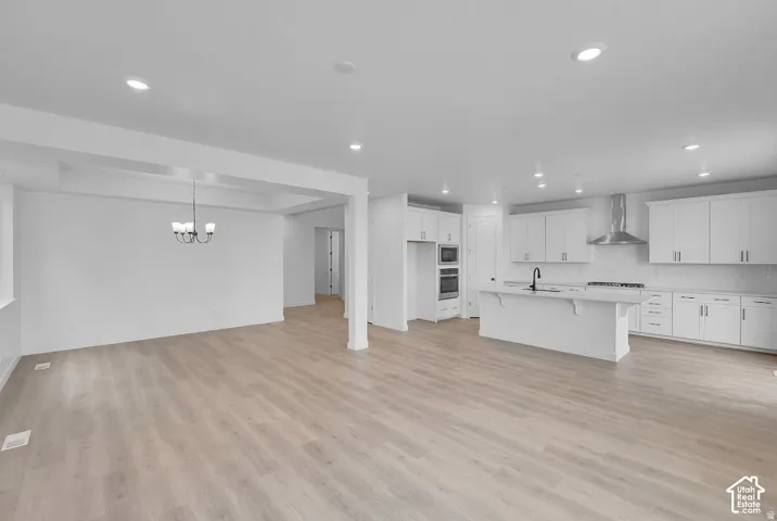 Open-concept floor plan with wood-finish flooring, recessed lighting, and a modern kitchen