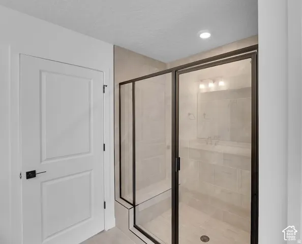 Walk-in shower with dark-framed glass enclosure, tiled walls, and built-in bench