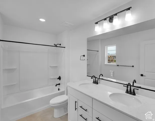 Dual vanity with integrated sinks, white cabinetry with black hardware, large wall-mounted mirror, and a white tub/shower combination with black fixtures