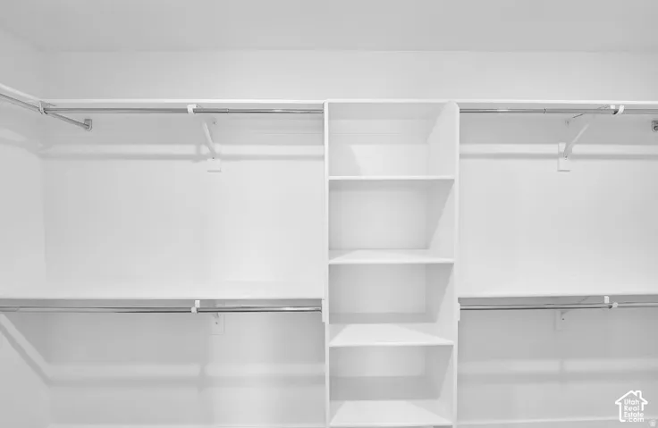Built-in closet organization system featuring white shelving and chrome hanging rods