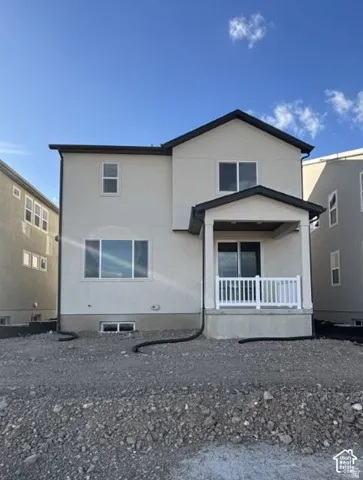 Two-story stucco exterior with a covered patio, white railing, and sliding glass door